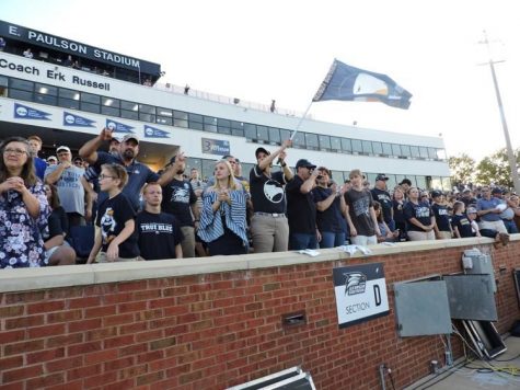 Fans wave a flag at a Georgia Southern football game. GS football games garner the highest attendance of varsity athletics, at nearly 13,000 attendees per game. 