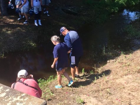 Head football coach Chad Lunsford and Interim President Shelly Nickel stood on the banks of the creek before stepping in