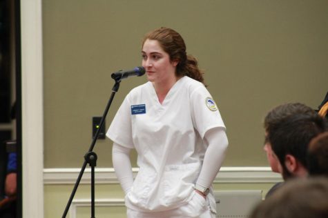 Georgia Southern junior nursing major Taylor Davis stands before the panel in her scrubs and shares her frustrations against the recent commencement changes during the Student Government Association meeting Wednesday. 