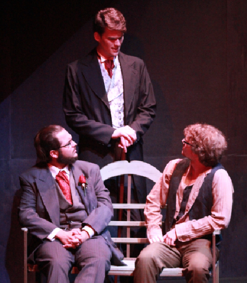 Berlioz played by Jacob Whitfield (seated left), Woland played by Andrew Shepherd (middle) and Ivan played by Nicholas Parrish (right) discuss their beliefs on Jesus Christ in a scene from “The Master and Margarita.”