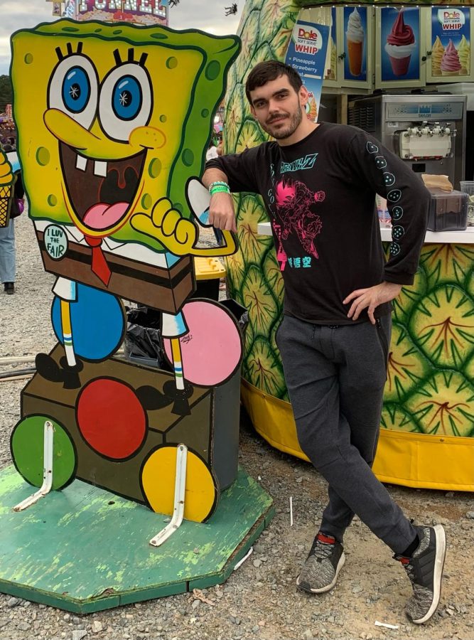 Photo of Ben chilling next to Spongebob at an attraction.