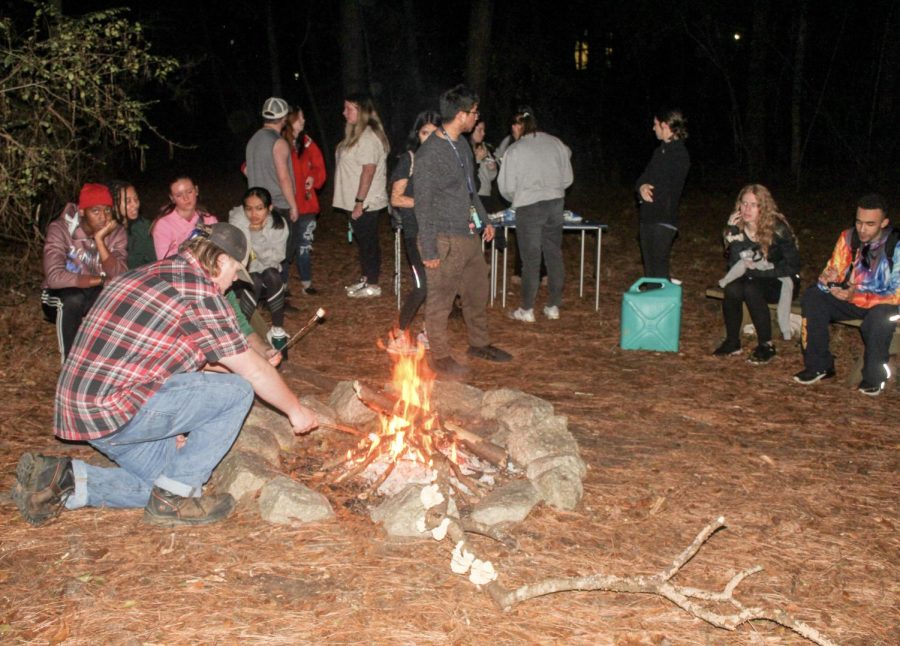 Students gathered together by the camp fire to make s'mores and enjoy the atmosphere.